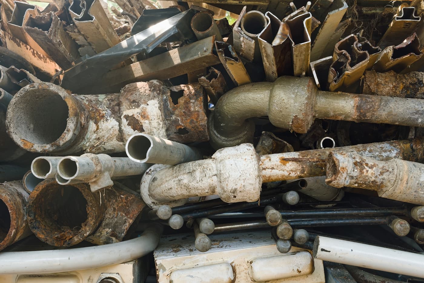 Pile of mixed scrap metal pipes awaiting sorting